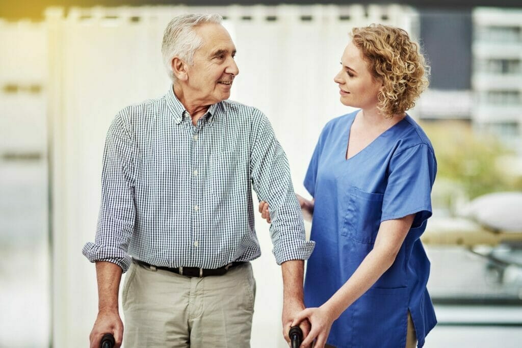 Senior man with walker being helped by nurse