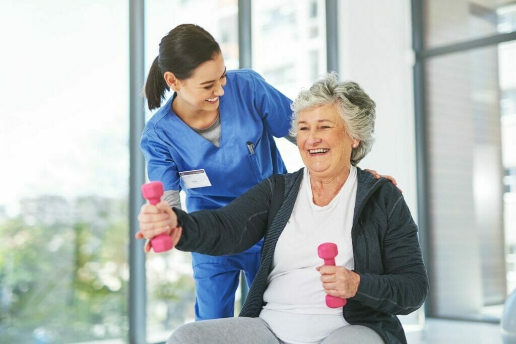 Senior woman exercising with nurse